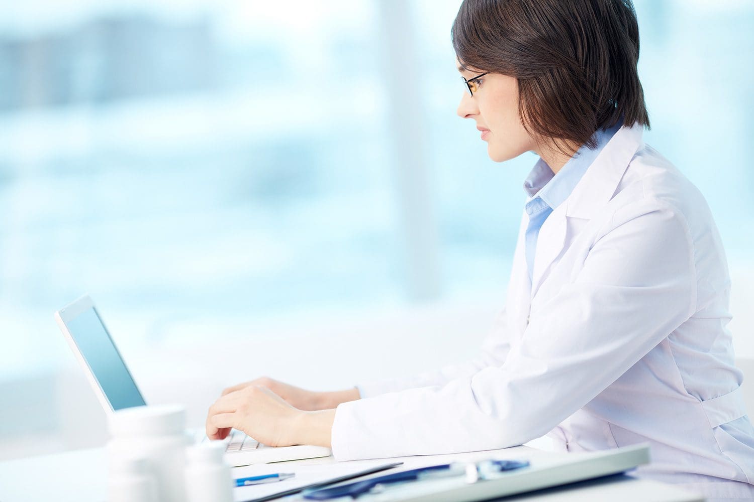 Female doctor typing on laptop